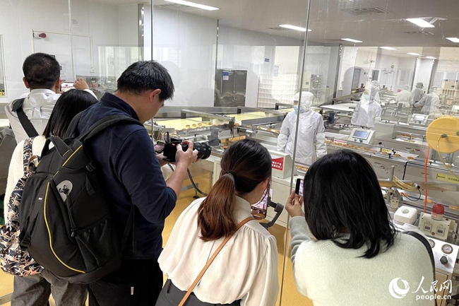 參賽記者參訪盼盼食品有限公司生產(chǎn)車間，拍攝取材。人民網(wǎng) 謝星宇攝
