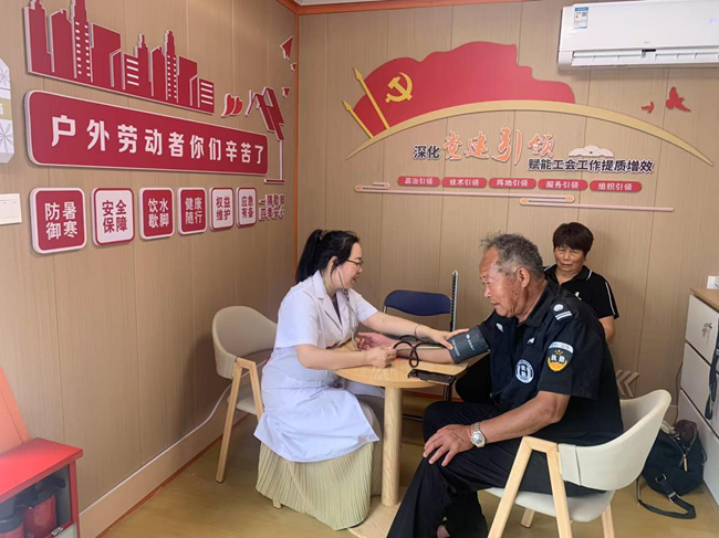 業(yè)務(wù)骨干在黨群暖心驛站內(nèi)為戶外勞動者免費義診