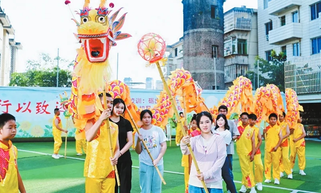 營員們在龍巖學(xué)院附屬小學(xué)與學(xué)生一同舞龍。龍巖市融媒體中心供圖