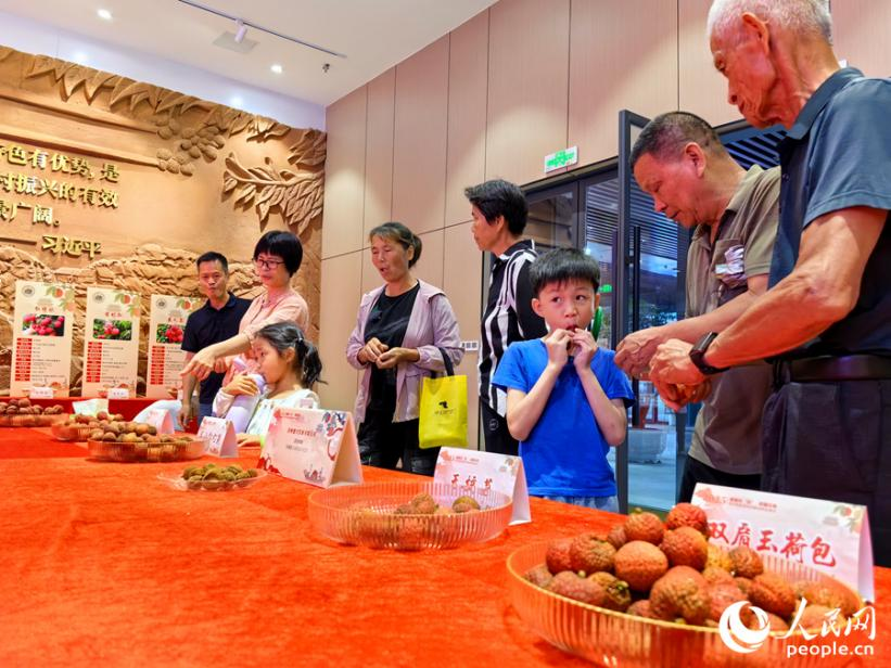 參與者在品嘗各品種荔枝。人民網(wǎng) 蘇海森攝